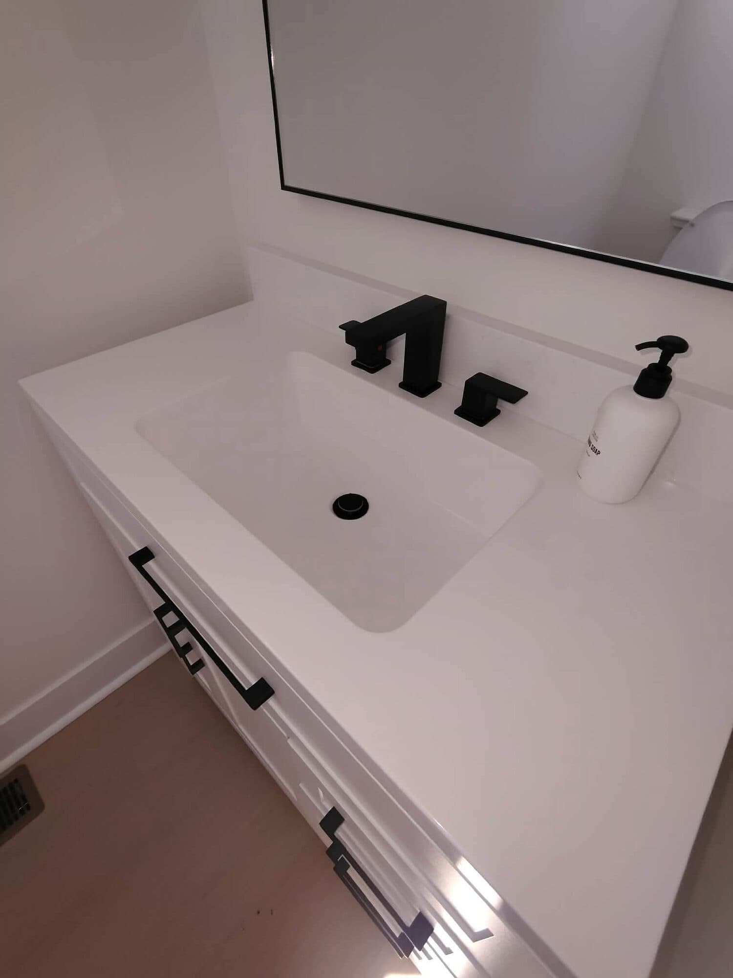 Spotless white bathroom vanity with black fixtures