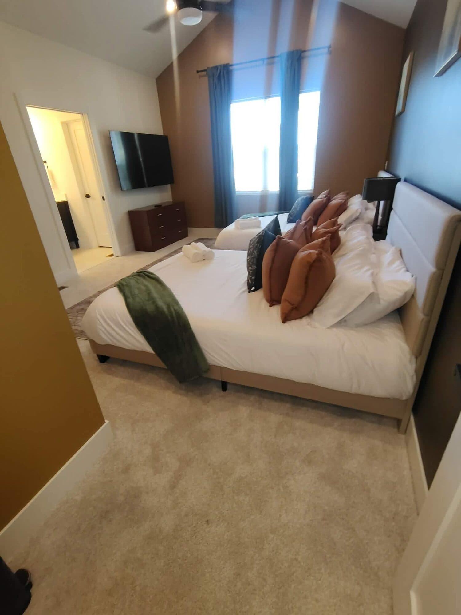 Primary bedroom with a freshly made bed and clean carpet