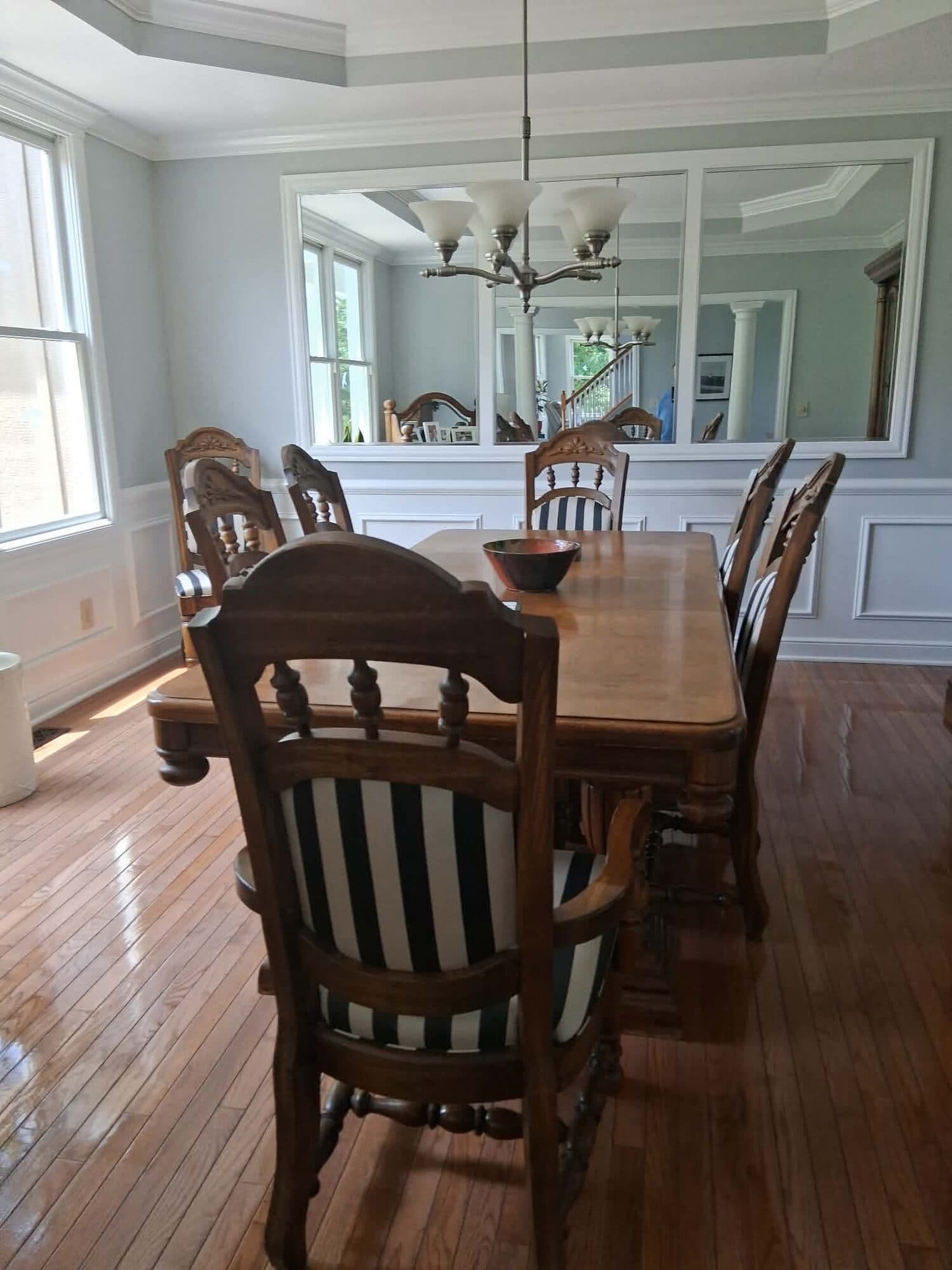 Formal dining room with polished hardwood floors and a wood table